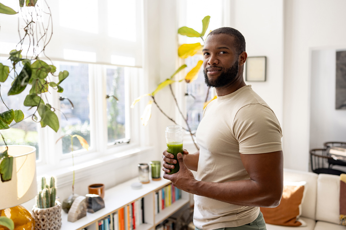 A fit man drinking a green smoothie in his home after getting GLP-1 injections in Sequim.