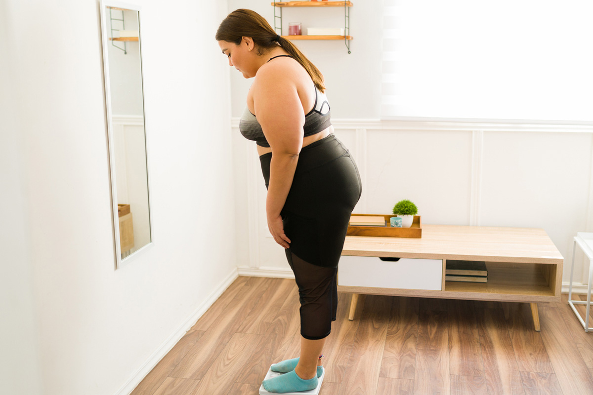 A fat woman looking at a scale after getting GLP-1 injections in Sequim.